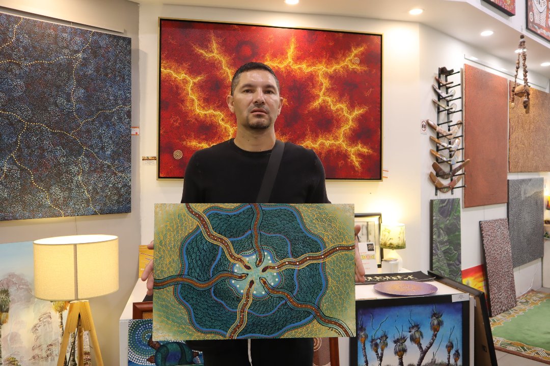 Jason Hapke holding Aboriginal Art of Snakes